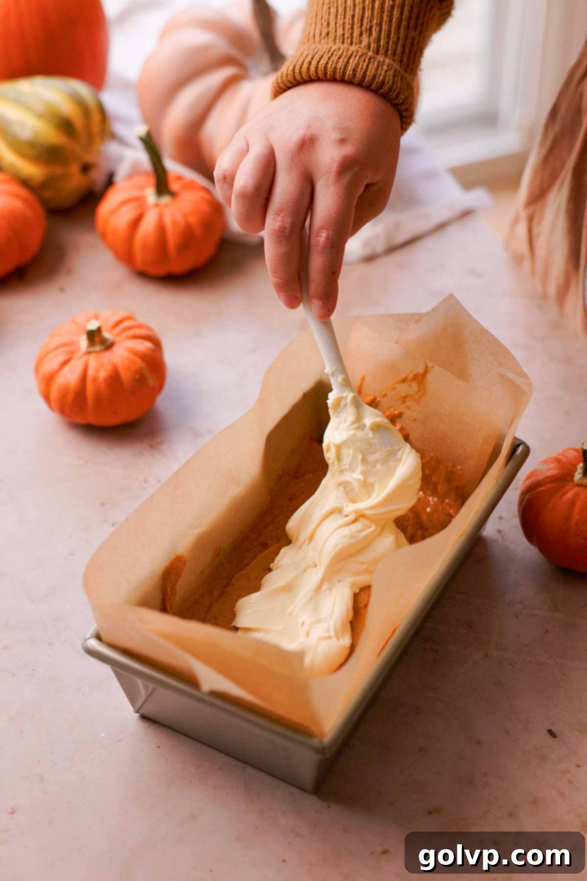 Autumn Pumpkin Streusel Cream Cheese Delight 10 layering cream cheese batter into the center of pumpkin bread with a spoon