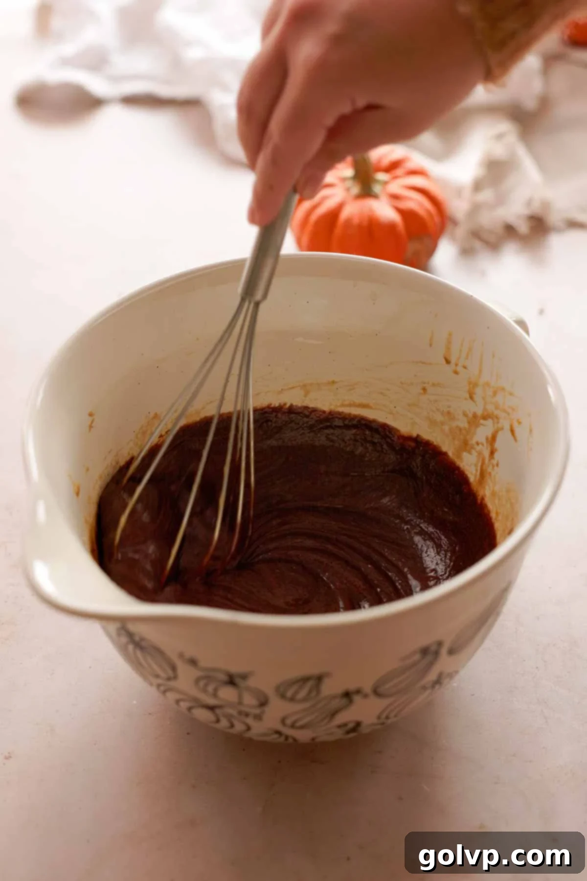 folding melted chocolate into brownie batter with a whisk
