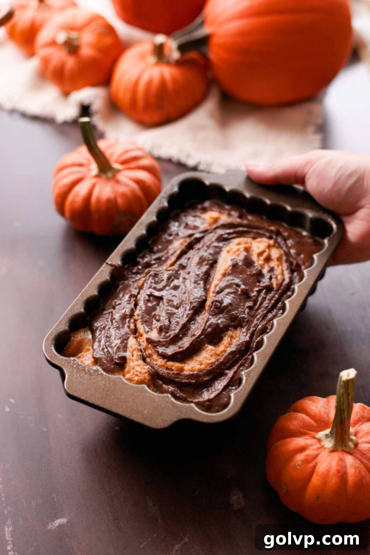 chocolate and pumpkin bread batter beautifully layered in a loaf pan, ready for baking