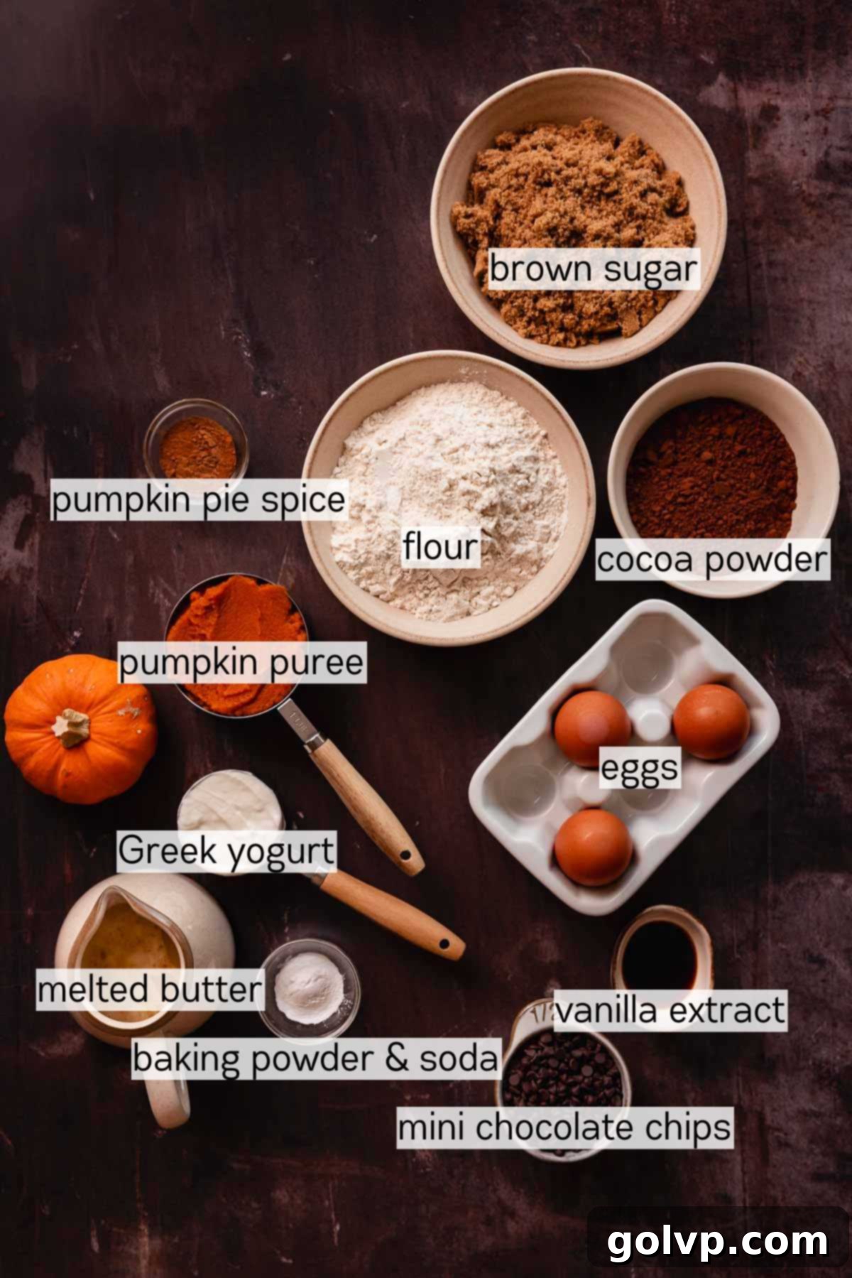 ingredients for pumpkin and chocolate bread in various bowls, neatly arranged