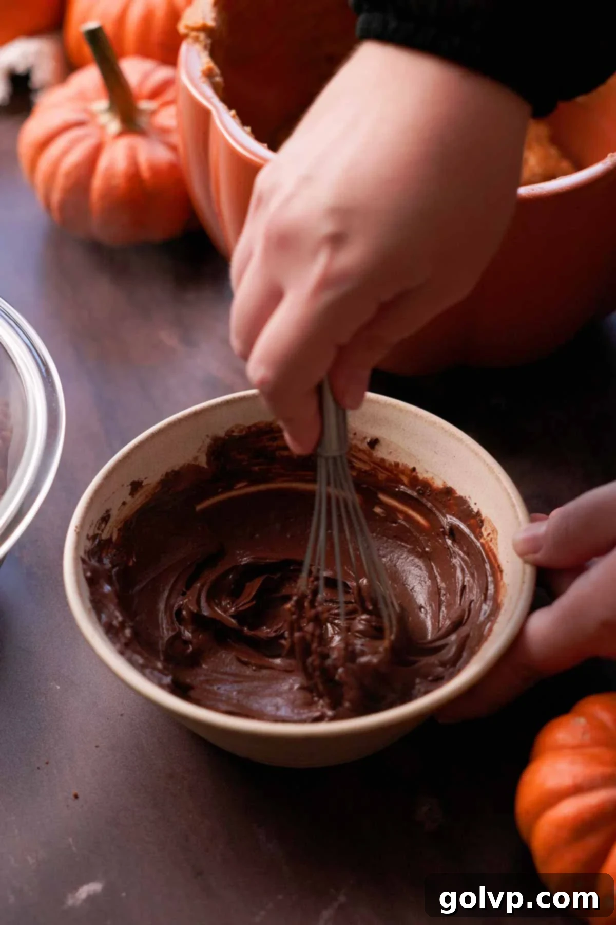 whisking cocoa powder and hot water in a small bowl with a wire whisk to create a smooth, glossy mixture