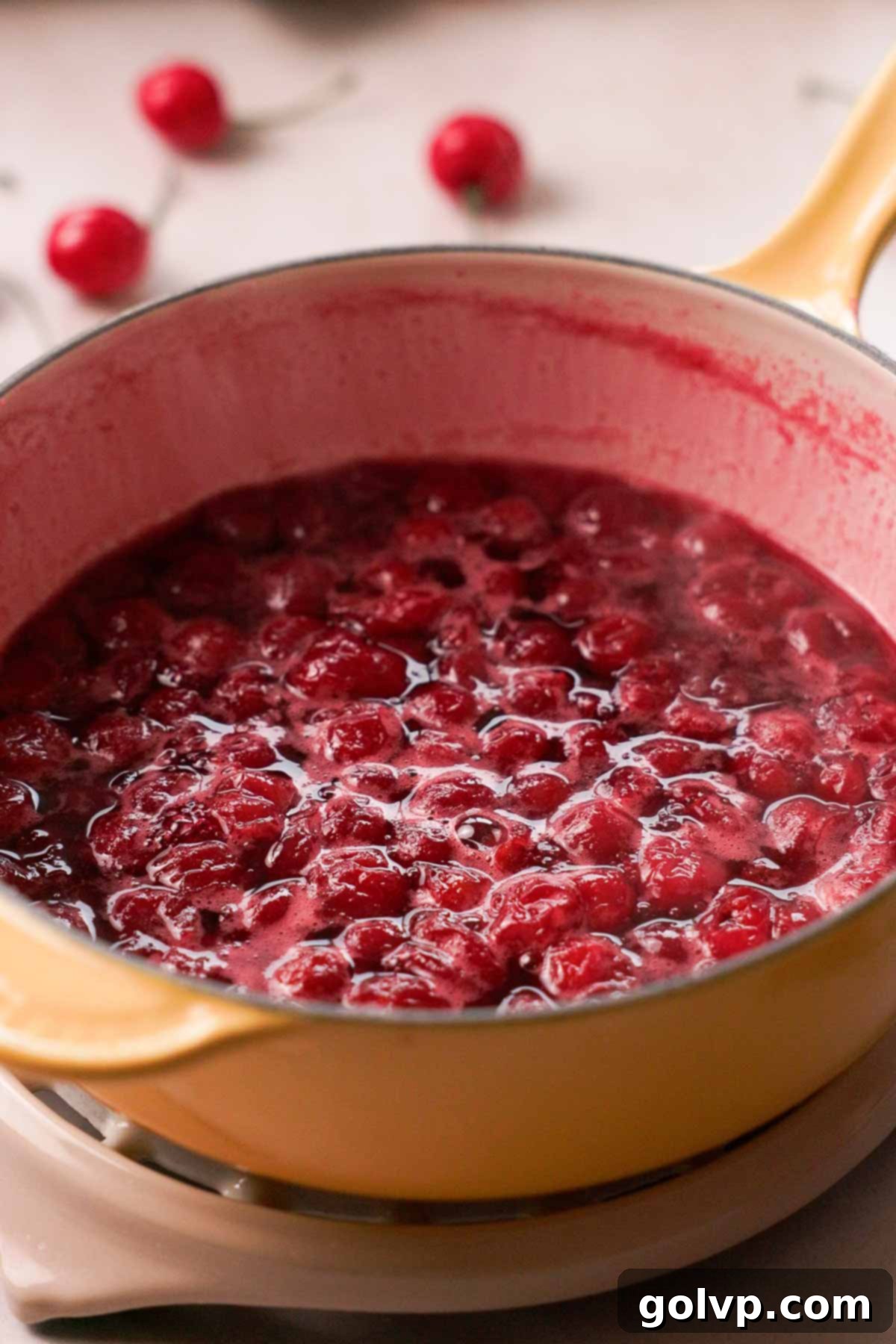 simmering cherry sauce in saucepan