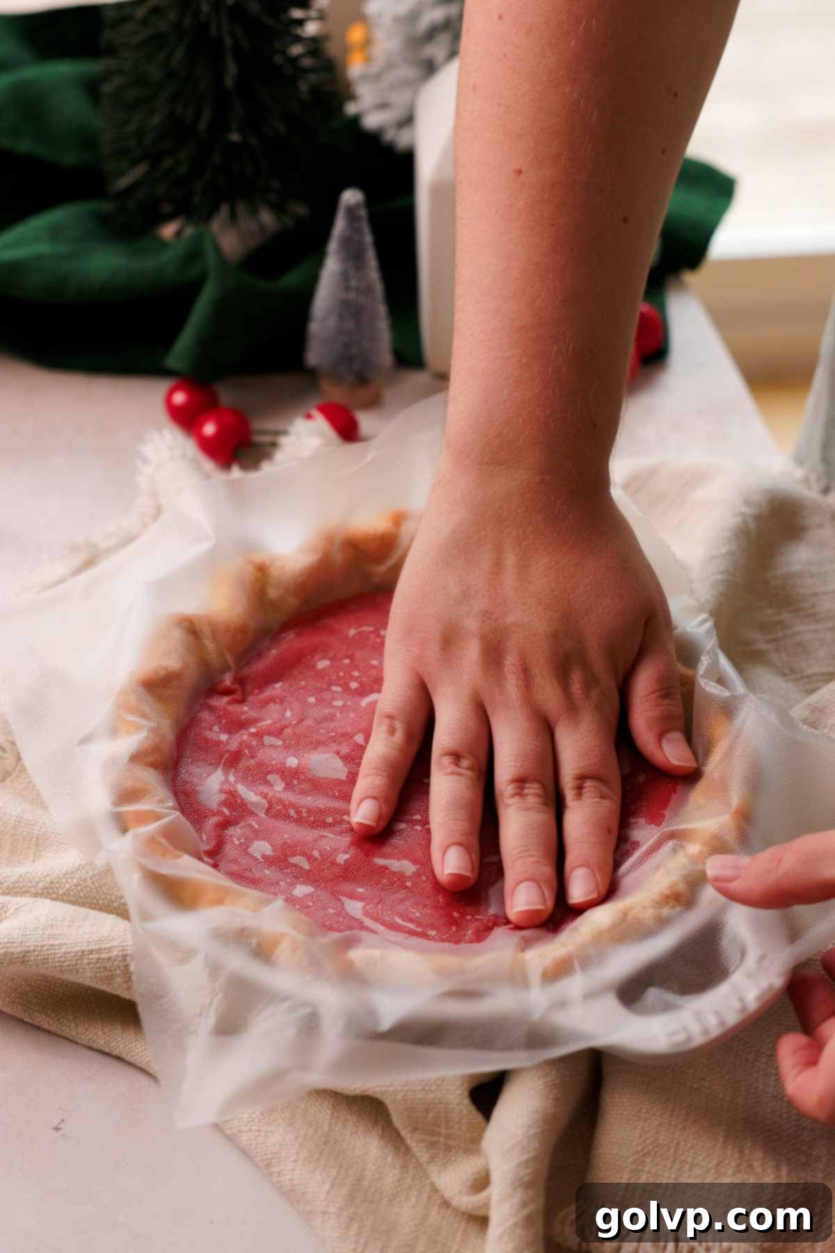 pressing cling film onto the surface of the tart cherry curd