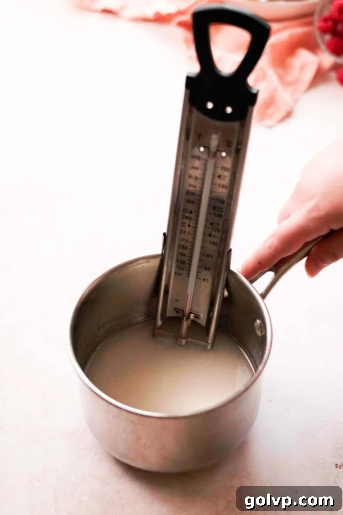 small saucepan with candy thermometer filled with sugar and water