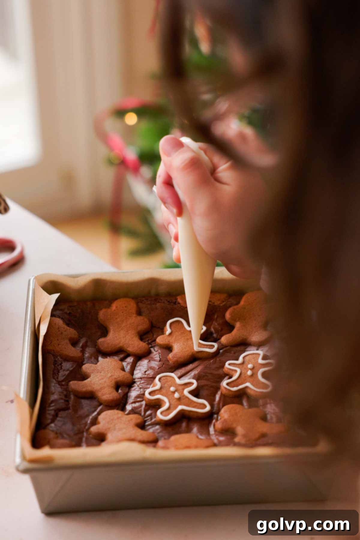 piping border onto gingerbread cookie brownies