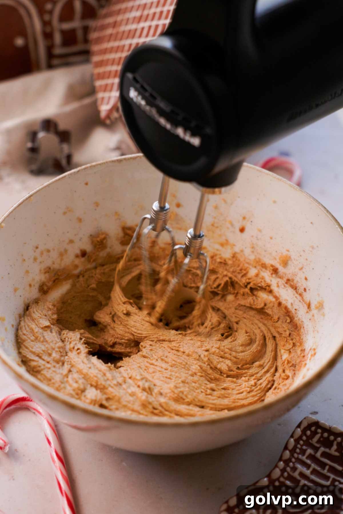 creaming gingerbread cookie dough wet ingredients with electric mixer in bowl