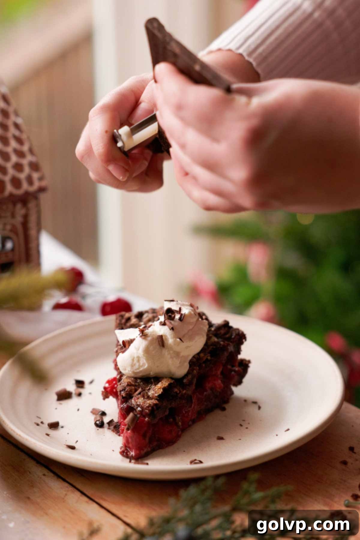 Decadent Chocolate Cherry Black Forest Pie 10 grating chocolate with a peeler over a slice of chocolate cherry pie