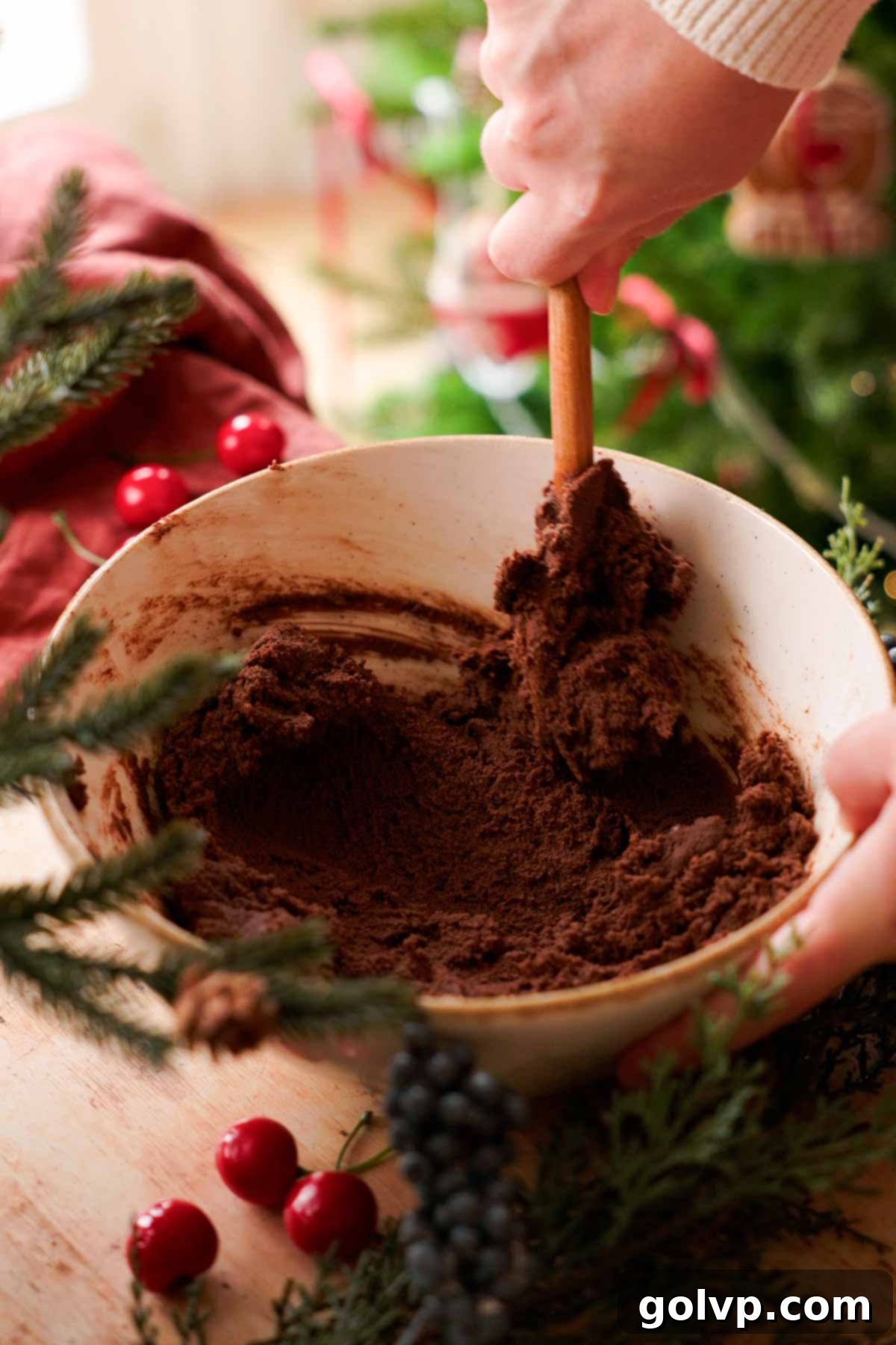 stirring chocolate almond cookie dough with wooden spoon