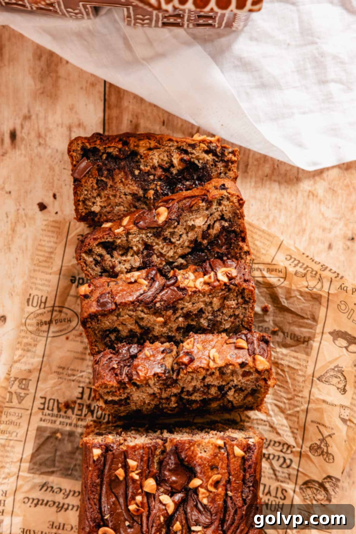Irresistible Nutella Banana Bread 2 slices of chocolate hazelnut banana bread with Nutella swirl on parchment paper