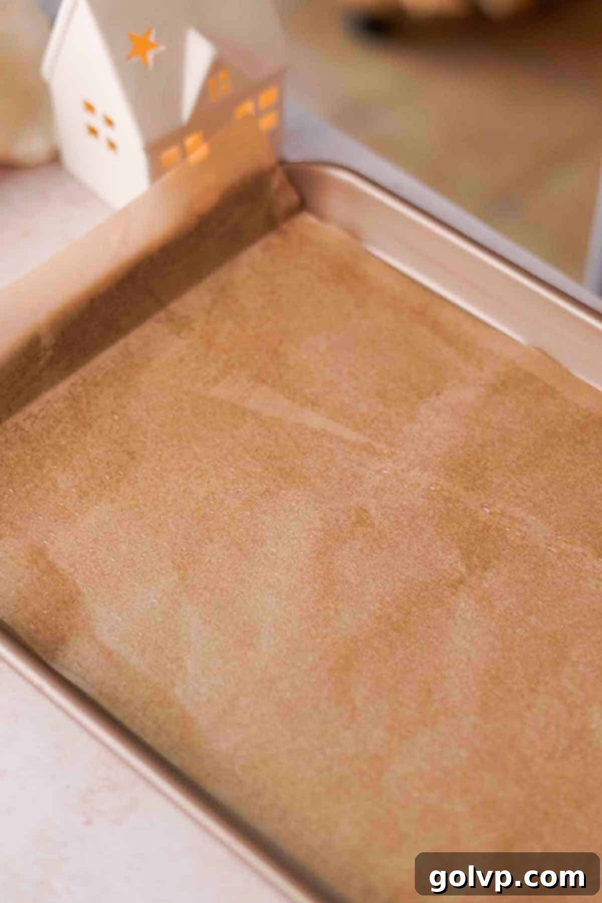 Baking sheet lined with parchment paper and lightly greased, ready for sponge cake batter.