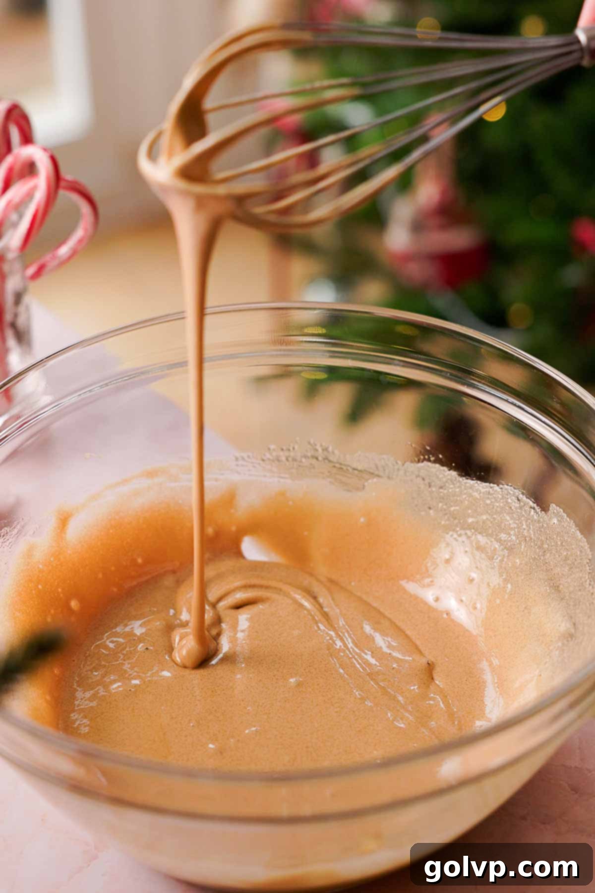 whisked sugar and eggs falling off a whisk in a ribbon stream, indicating proper aeration