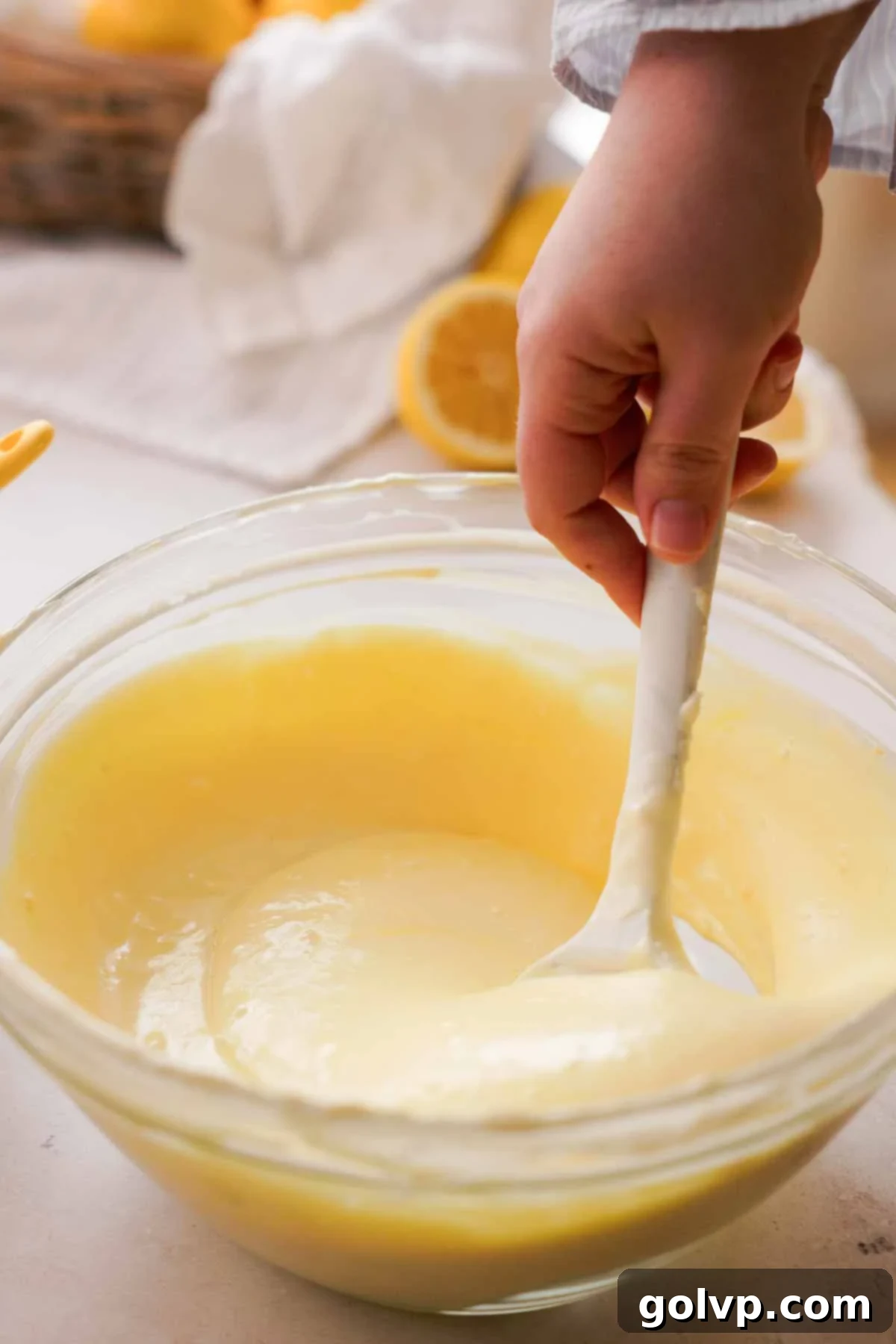 Lemon Poppy Seed Cheesecake Perfection 12 stirring lemon cheesecake batter with a silicone spatula