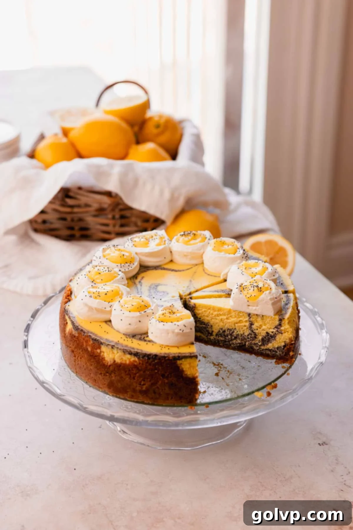 Lemon Poppy Seed Cheesecake Perfection 21 lemon cheesecake with poppy seed swirls on glass cake stand
