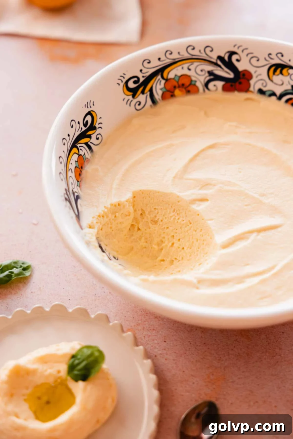 Large bowl of creamy lemon curd mousse with a scoop removed, showing its stable texture.