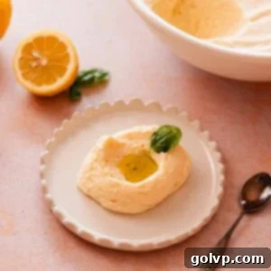 scoop of lemon mousse with lemon curd, olive oil, and basil leaf