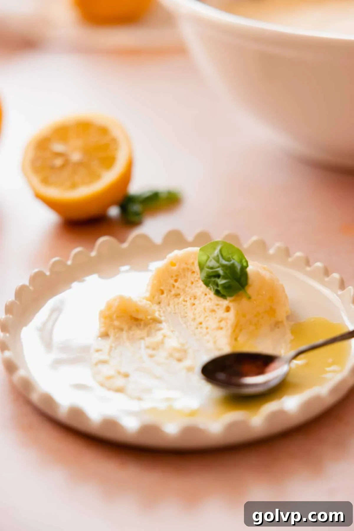 small plate with almost eaten scoop of lemon mousse with olive oil and basil leaf