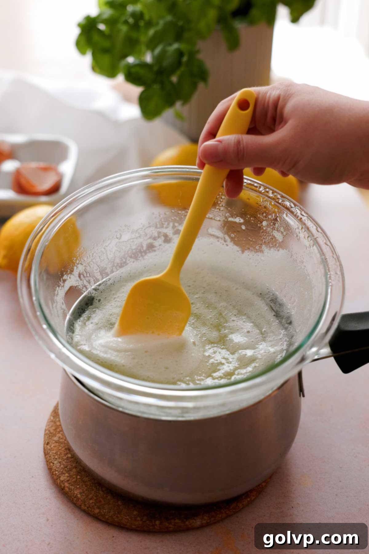 Preparing Swiss meringue: whisking egg whites and sugar over a double boiler until sugar dissolves and mixture is warm.