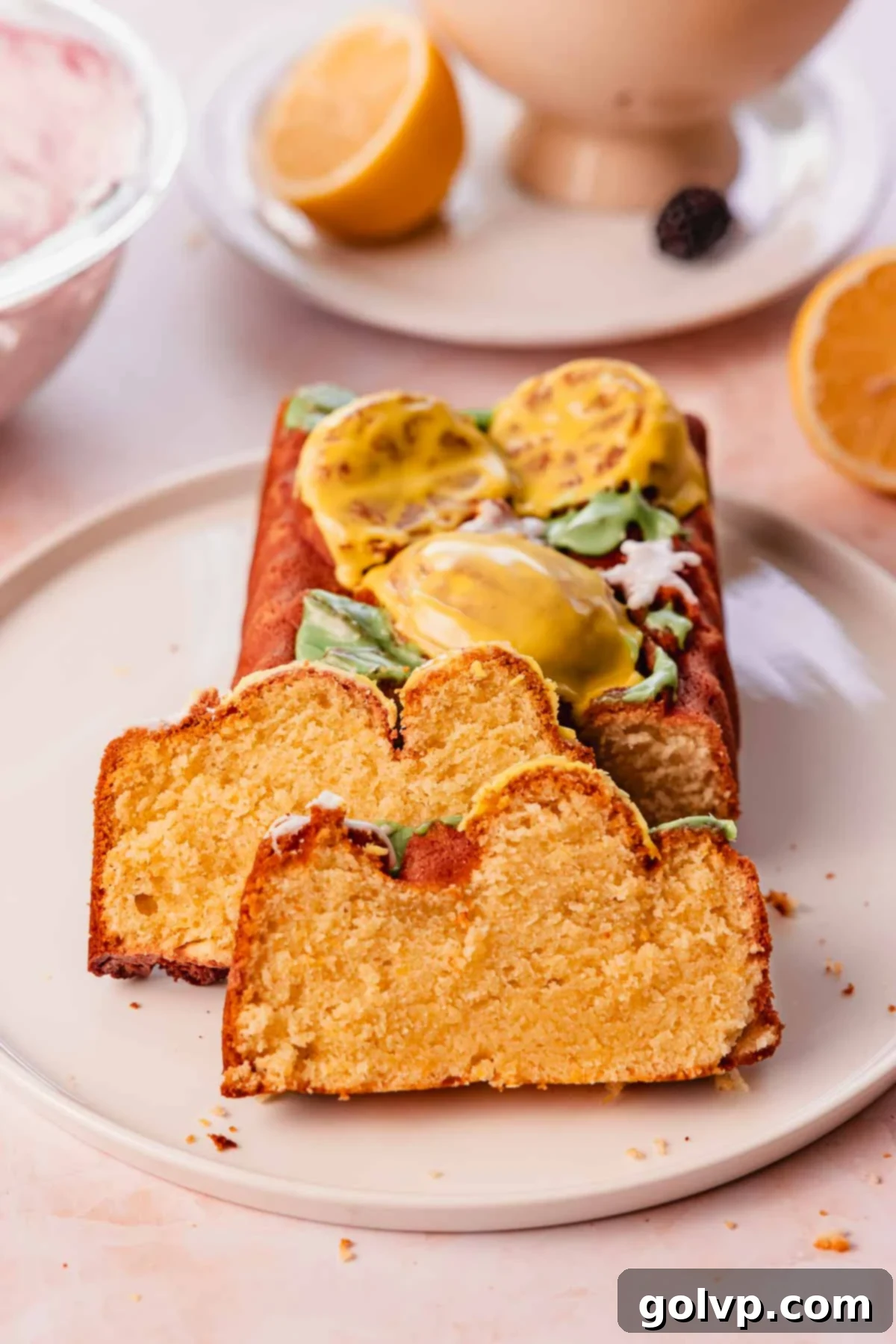 slices of moist lemon pound cake on a large plate, garnished with fresh blackberries and mint