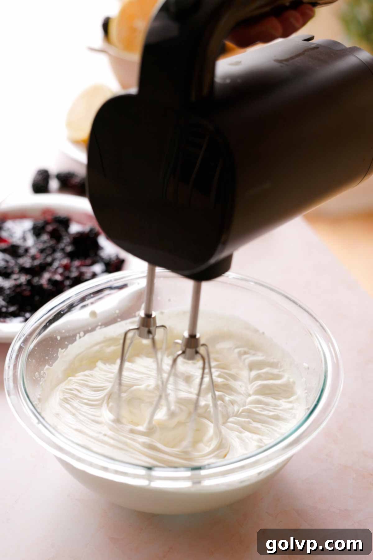 whipping heavy cream in a large bowl with an electric mixer to stiff peaks