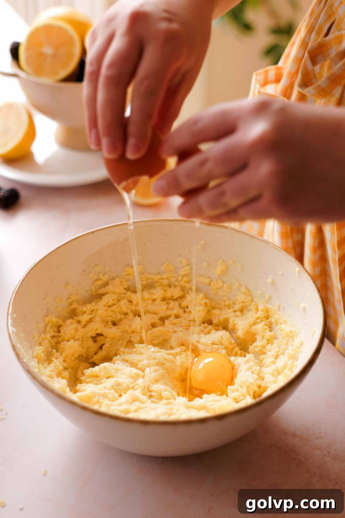 adding one egg at a time to the lemon pound cake batter, beating well after each addition