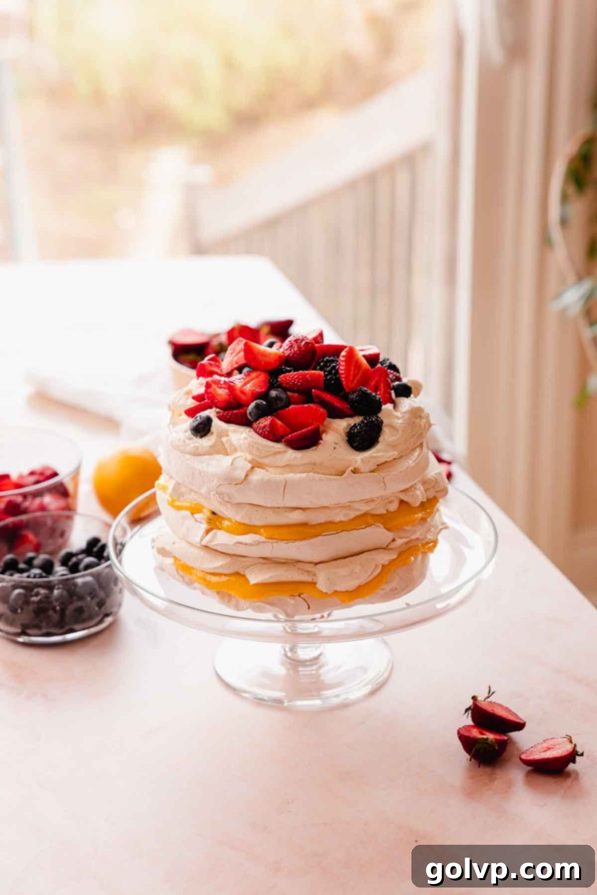 stacked pavlova cake with lemon passion fruit curd and berries