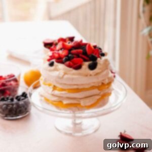 stacked pavlova cake with lemon passion fruit curd and berries