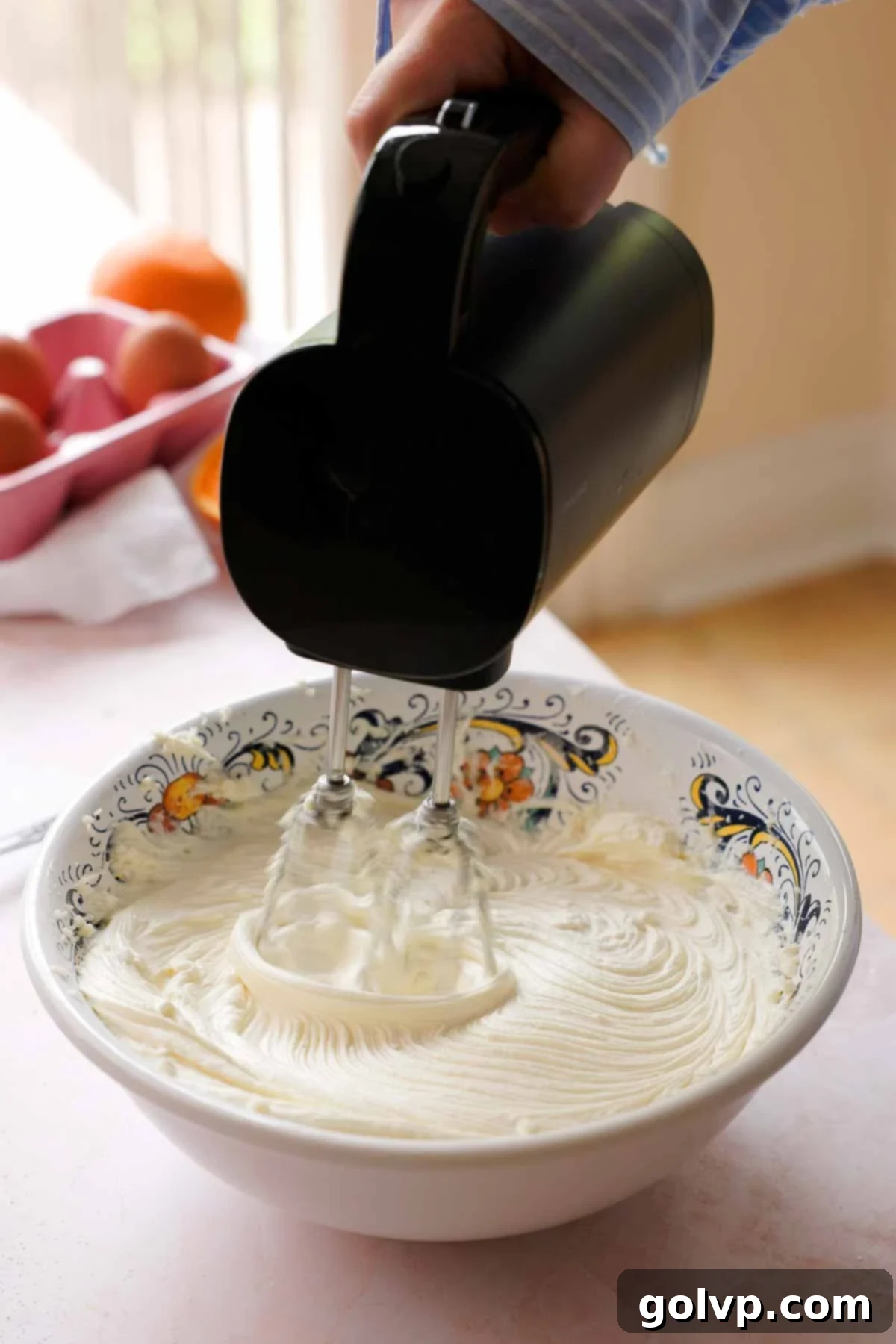 beating cream cheese and sugar with electric mixer in large bowl
