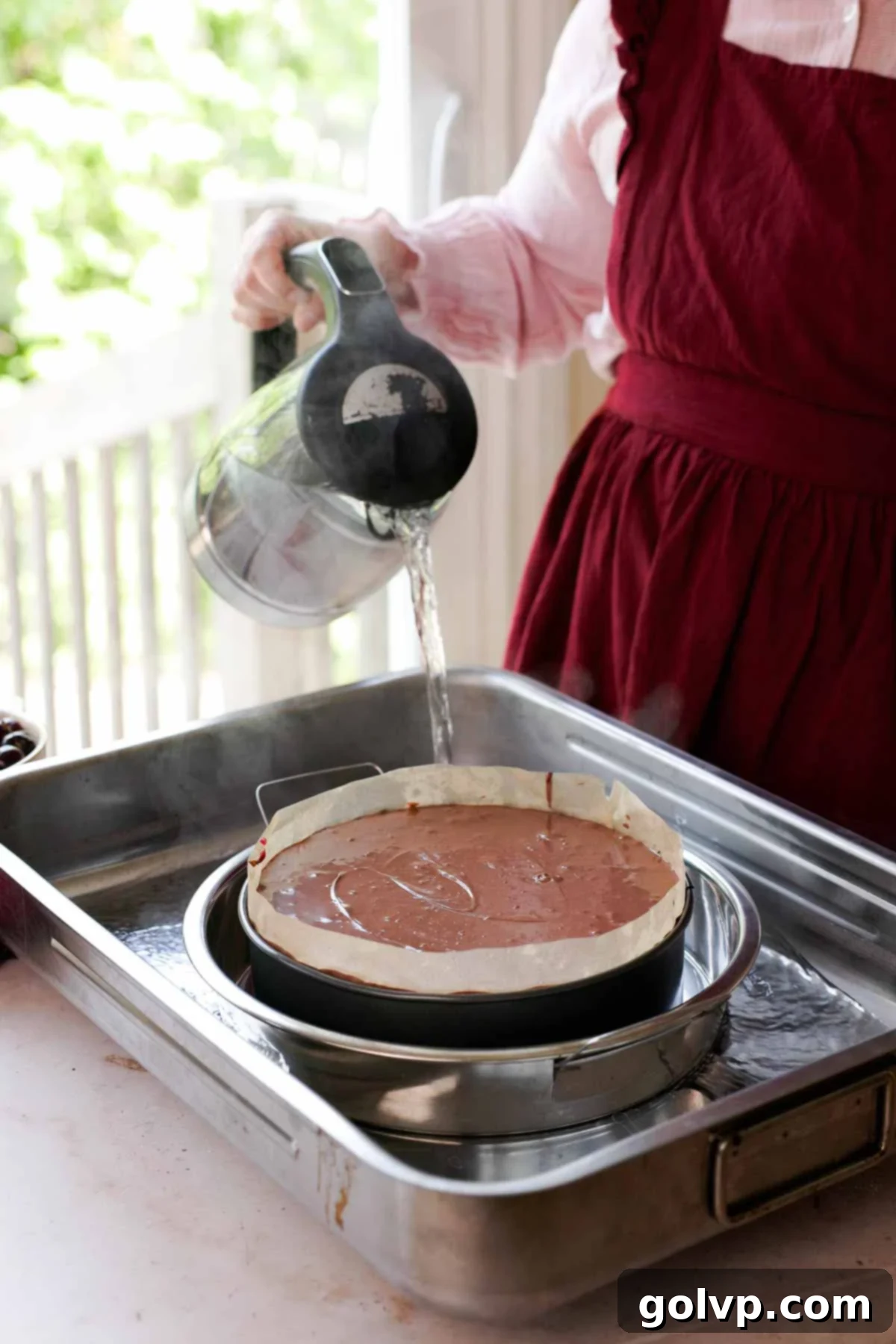 pouring boiling water into double bath for cheesecake