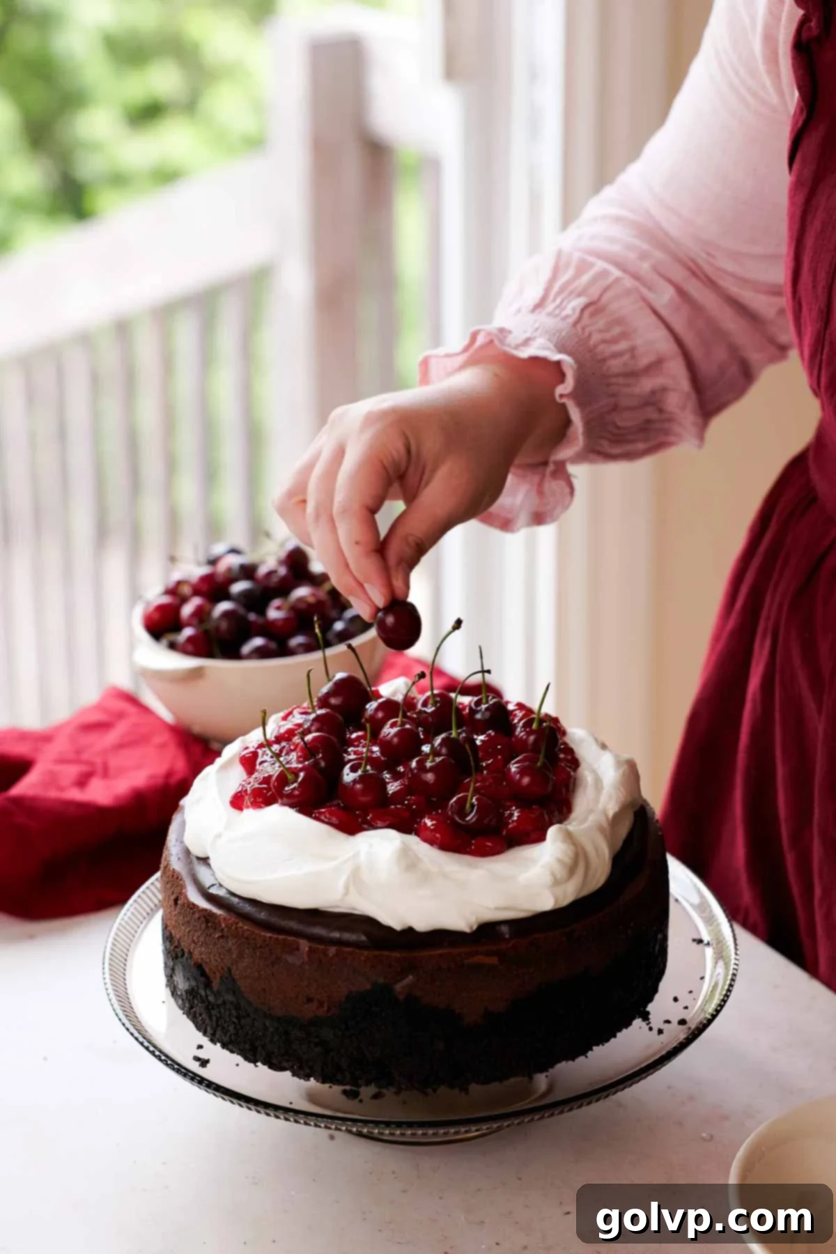 adding fresh cherries onto black forest cheesecake