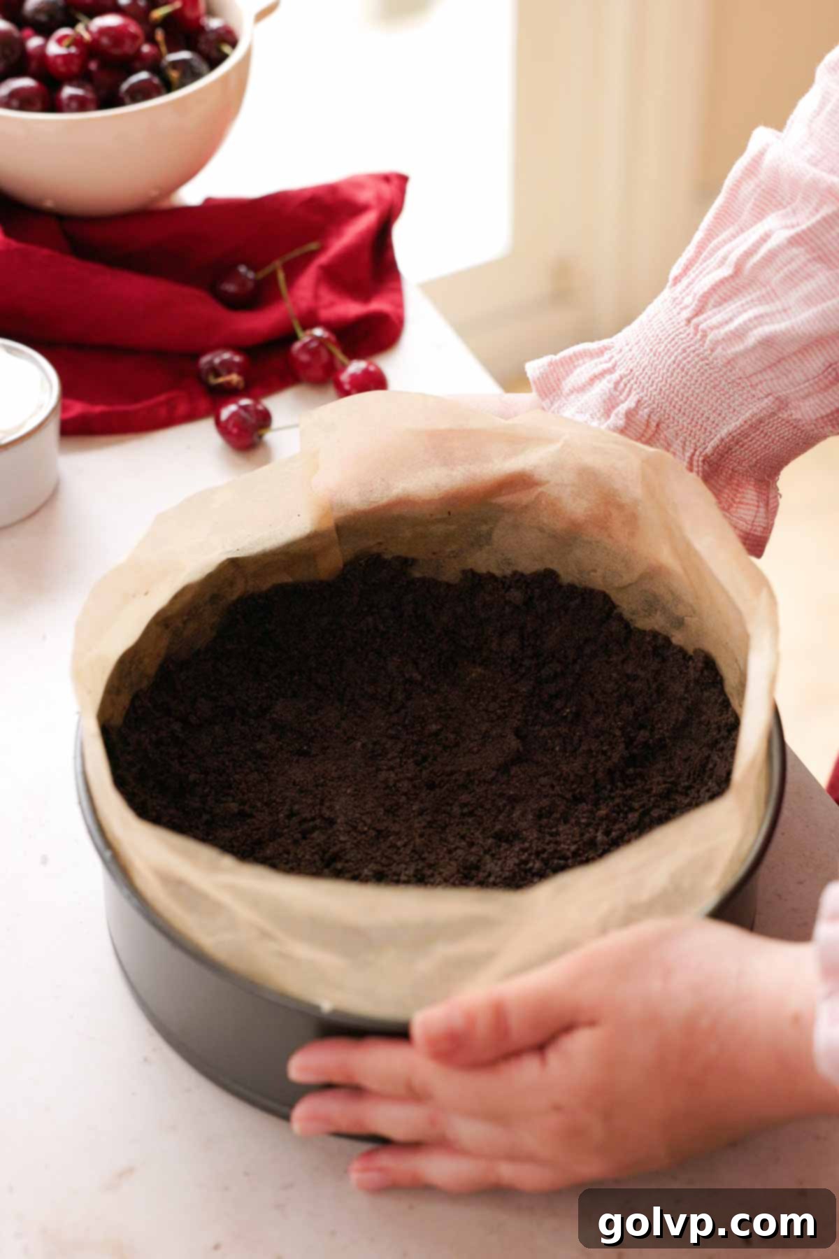 oreo crust in springform pan with parchment paper ring