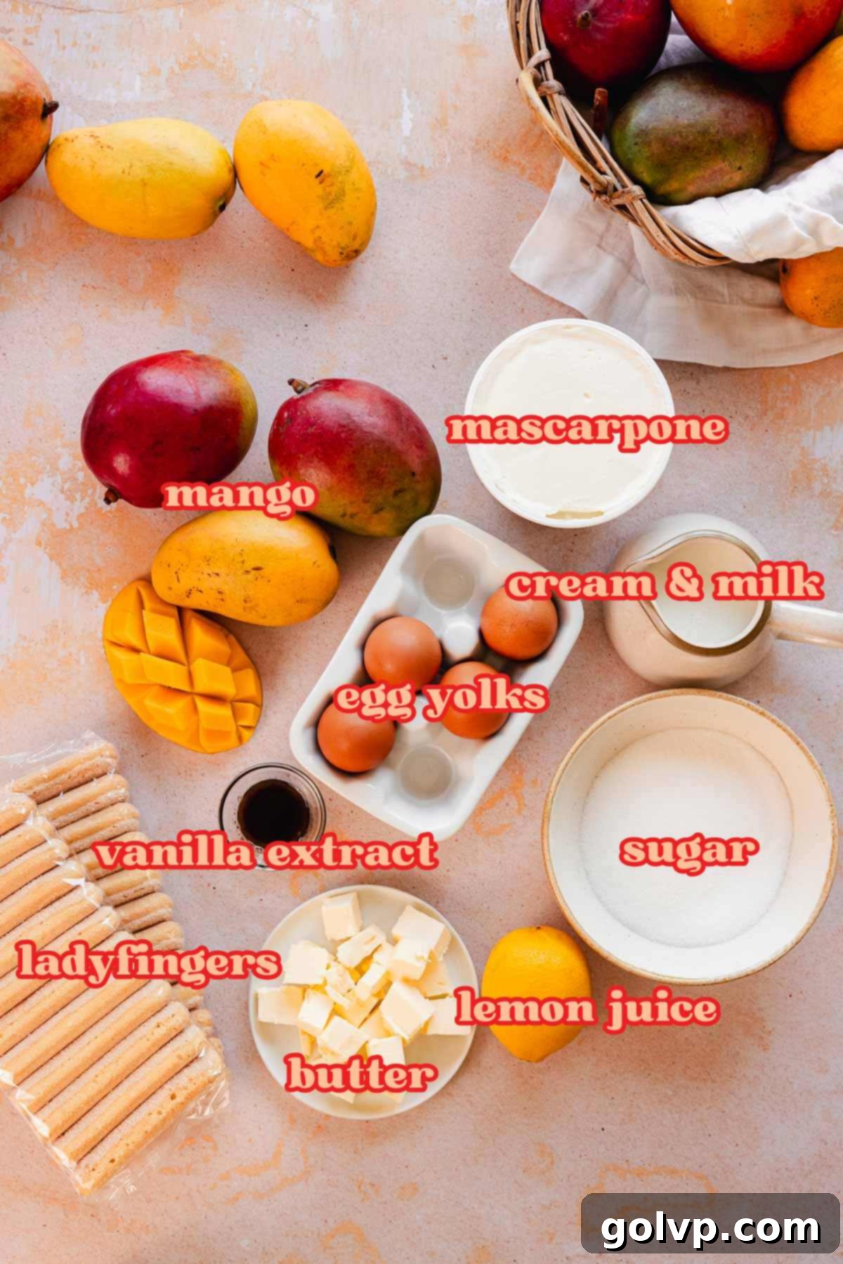 Various ingredients for mango tiramisu laid out in small white bowls on a light surface, including fresh mango chunks, egg yolks, butter, sugar, and vanilla, ready for preparation.