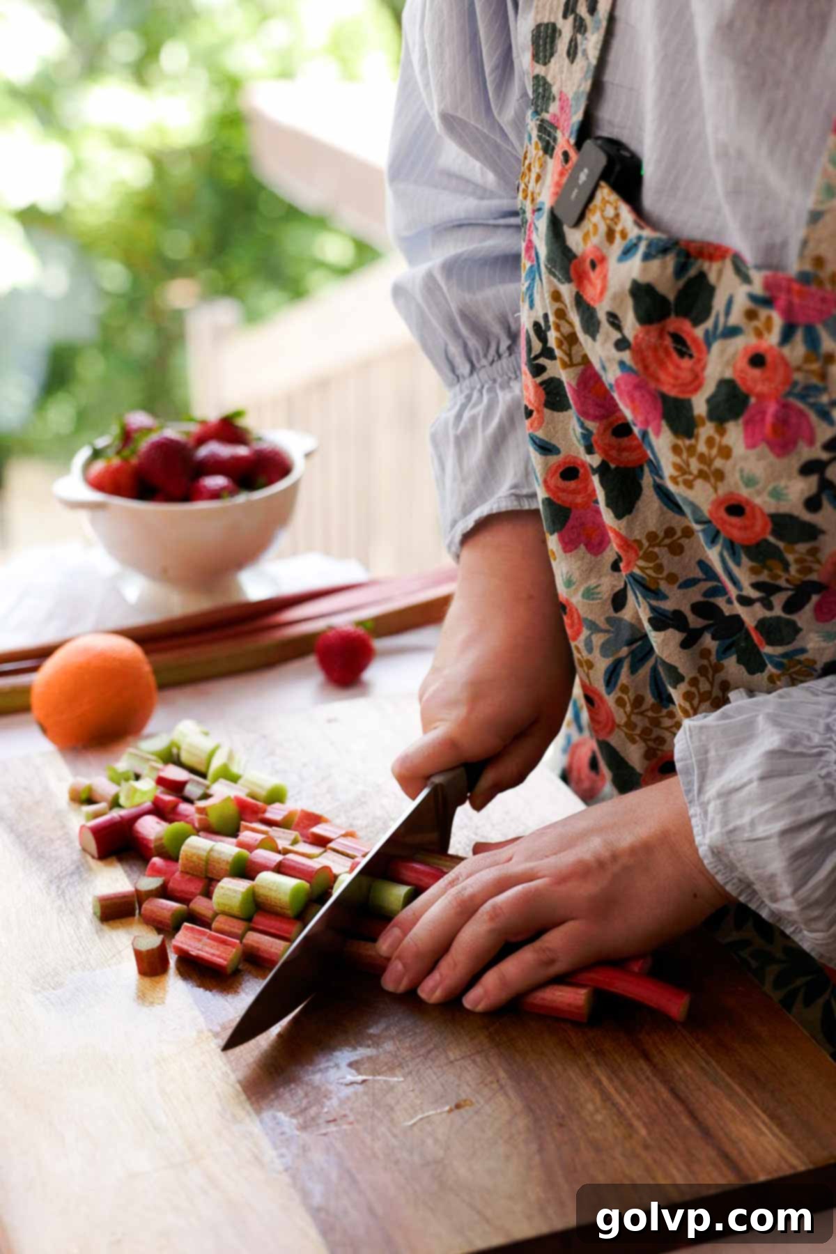 chopping rhubarb into chunks on cutting board