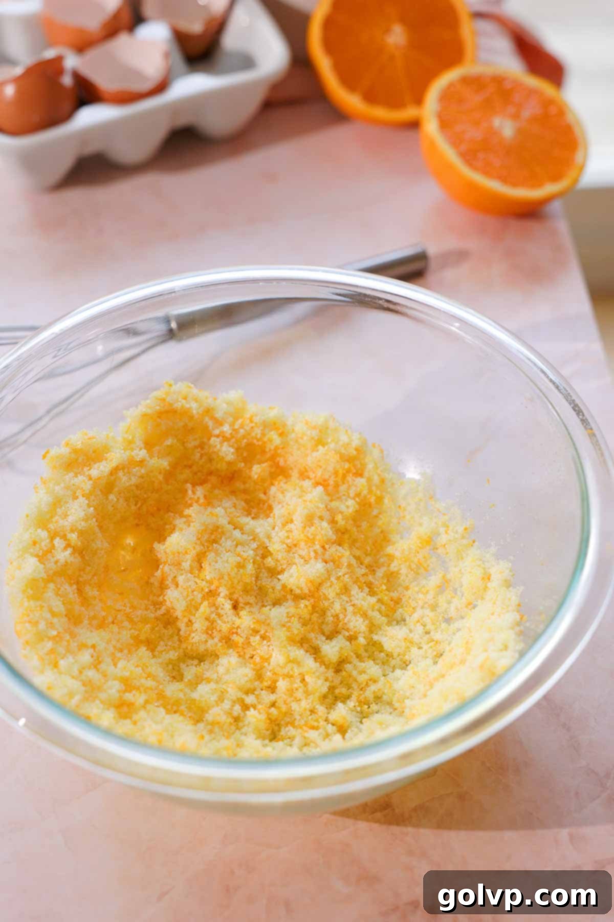 orange zest and sugar mixed together in a glass bowl