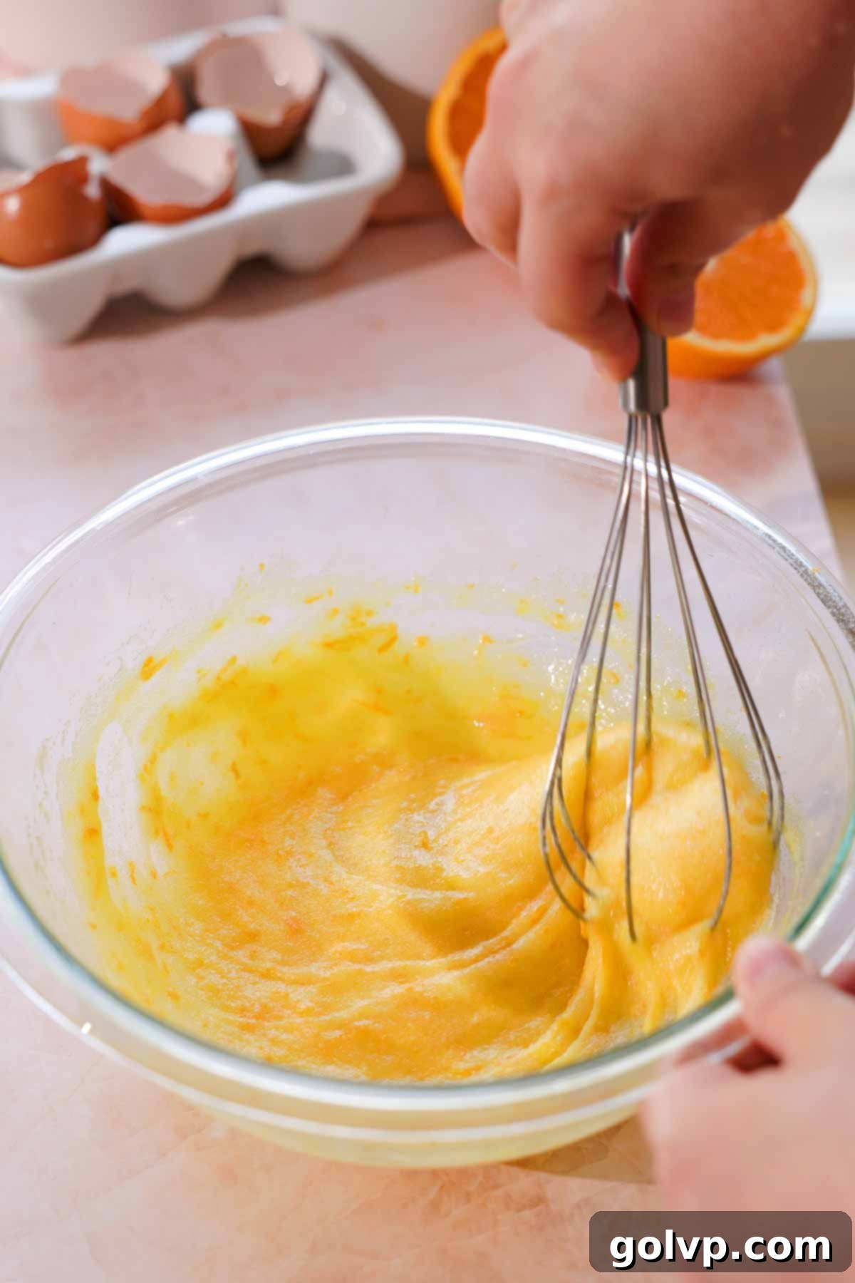 whisking orange zest and sugar in large glass bowl