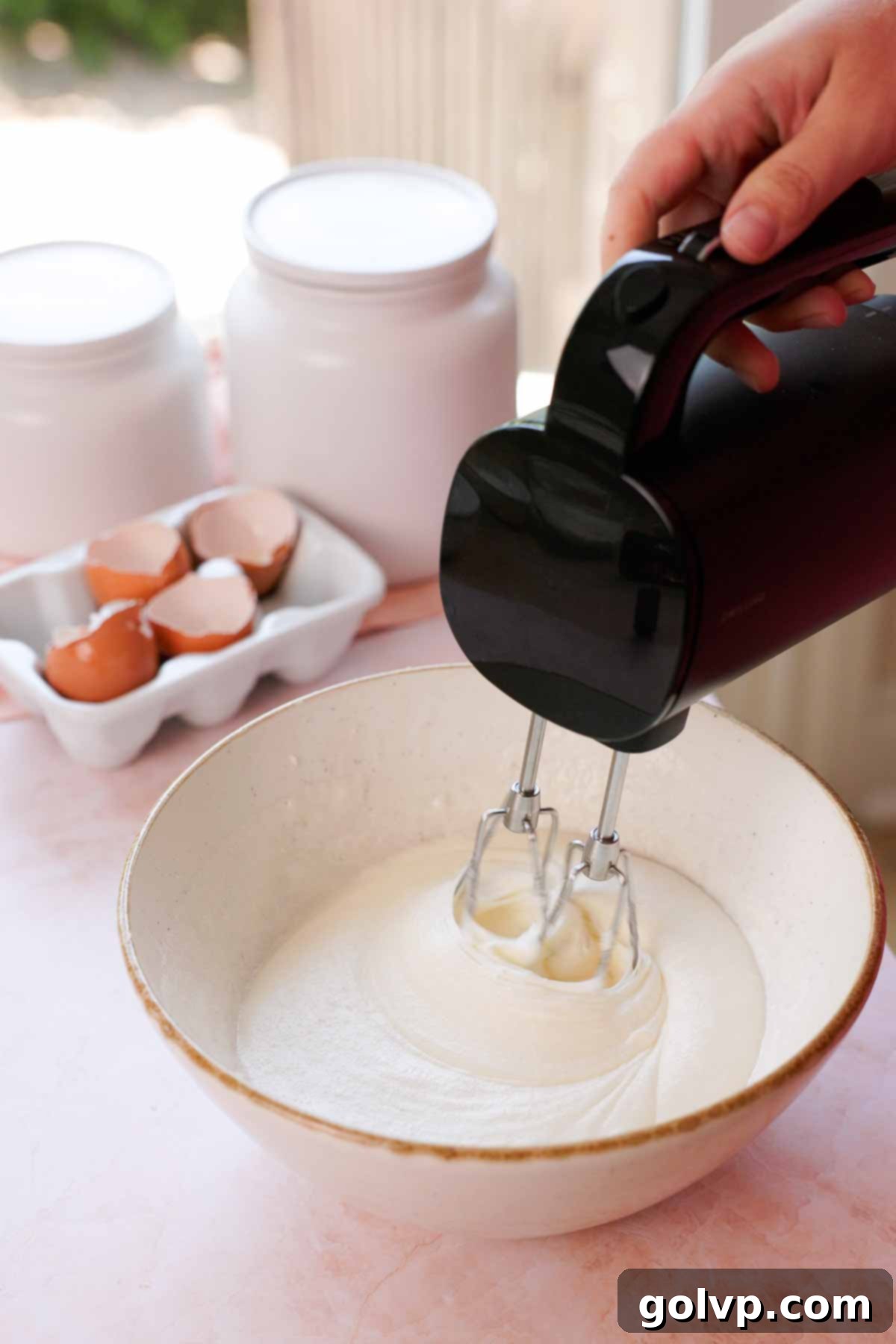 beating oil, sugar, and egg whites in large bowl with mixer