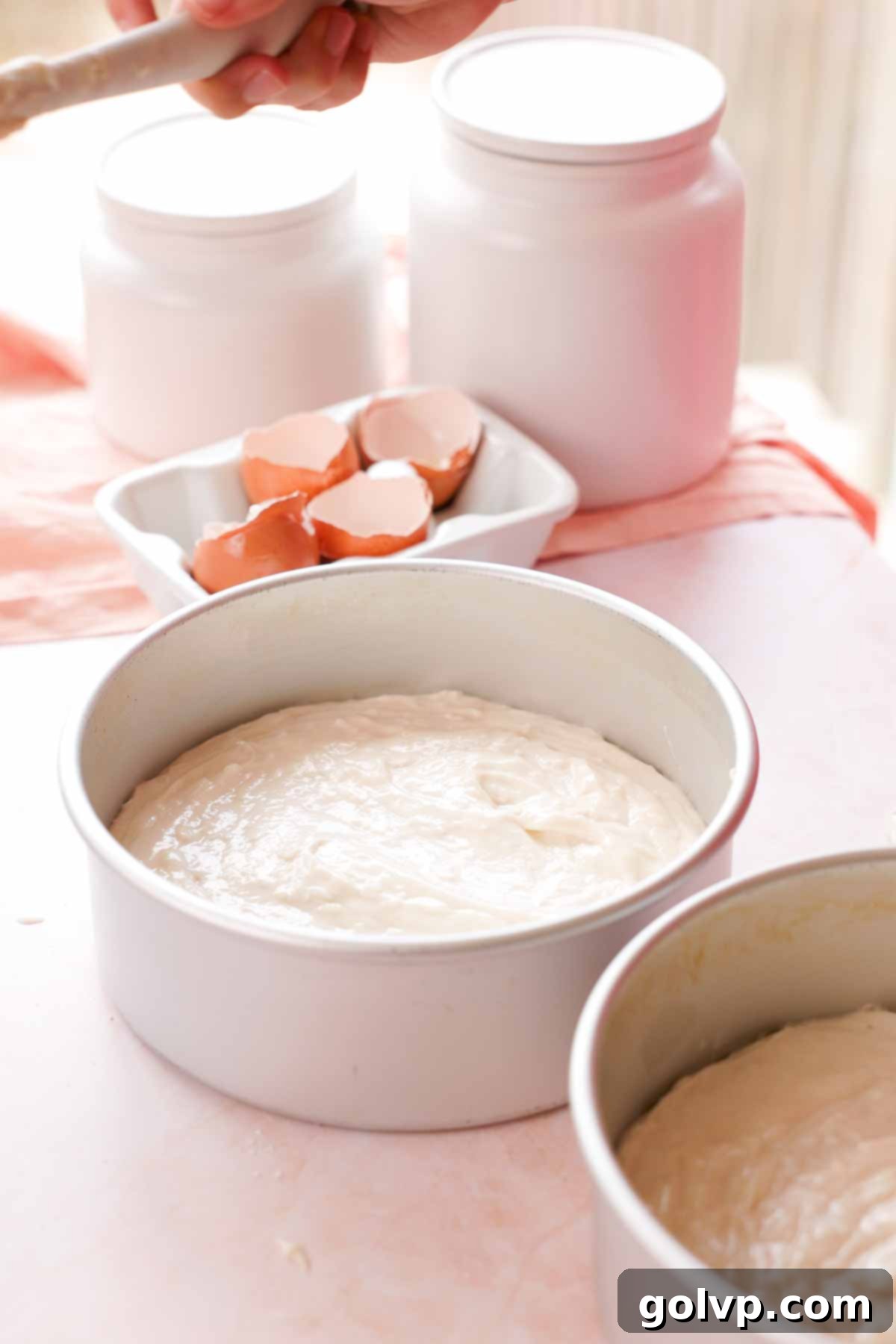 coconut cake batter in cake pans
