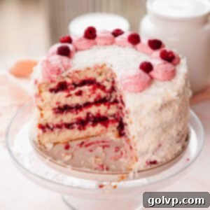 coconut layer cake with raspberry filling on cake stand