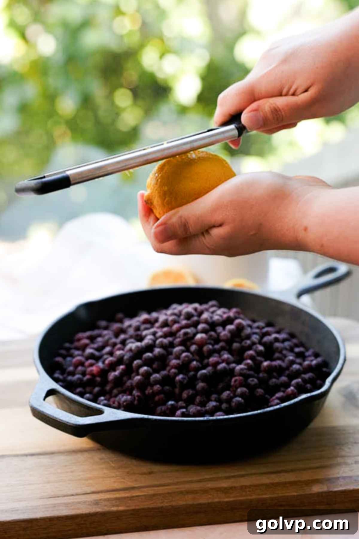 zesting a lemon into skillet with frozen wild blueberries