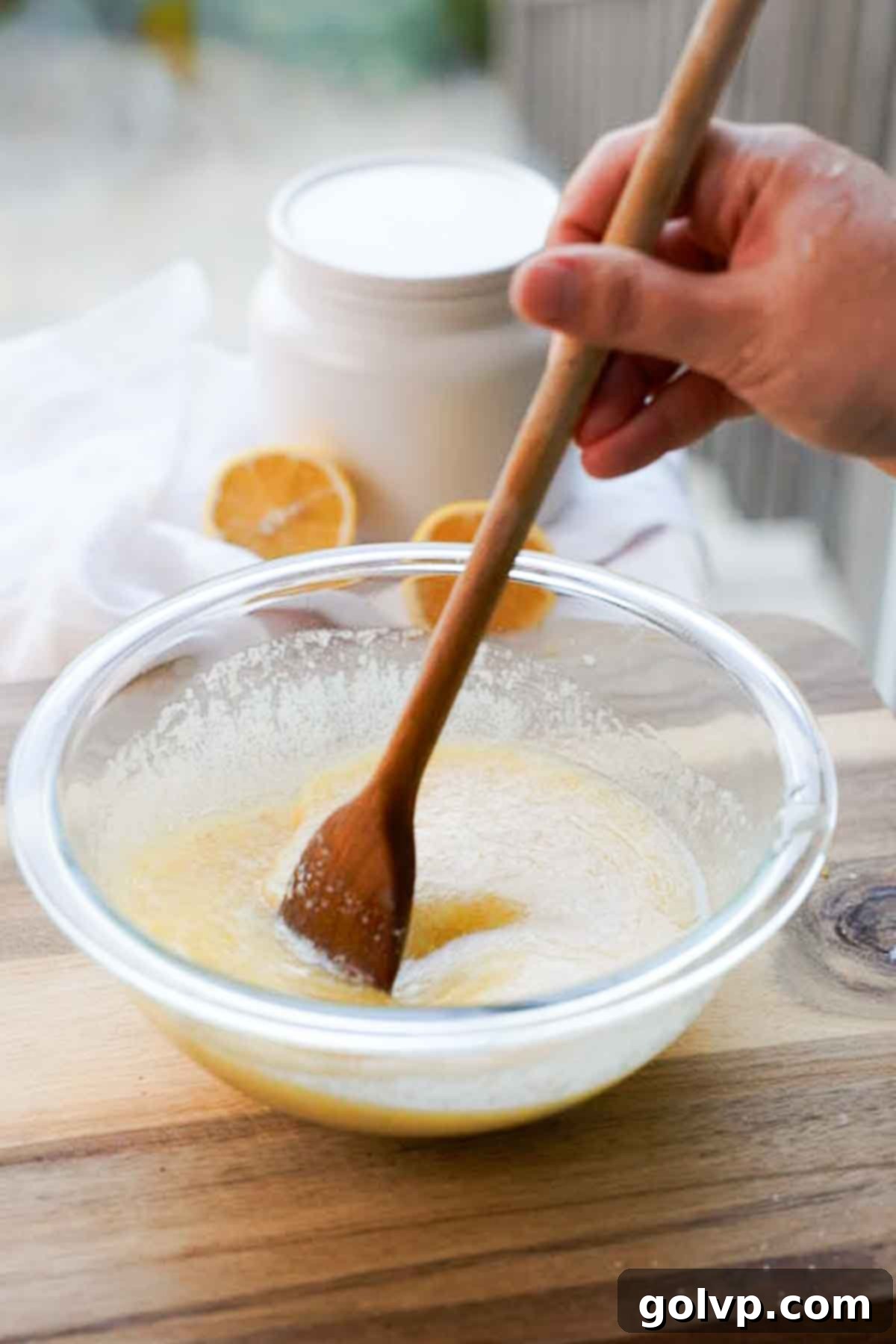 mixing wet ingredients for cobbler batter in glass bowl