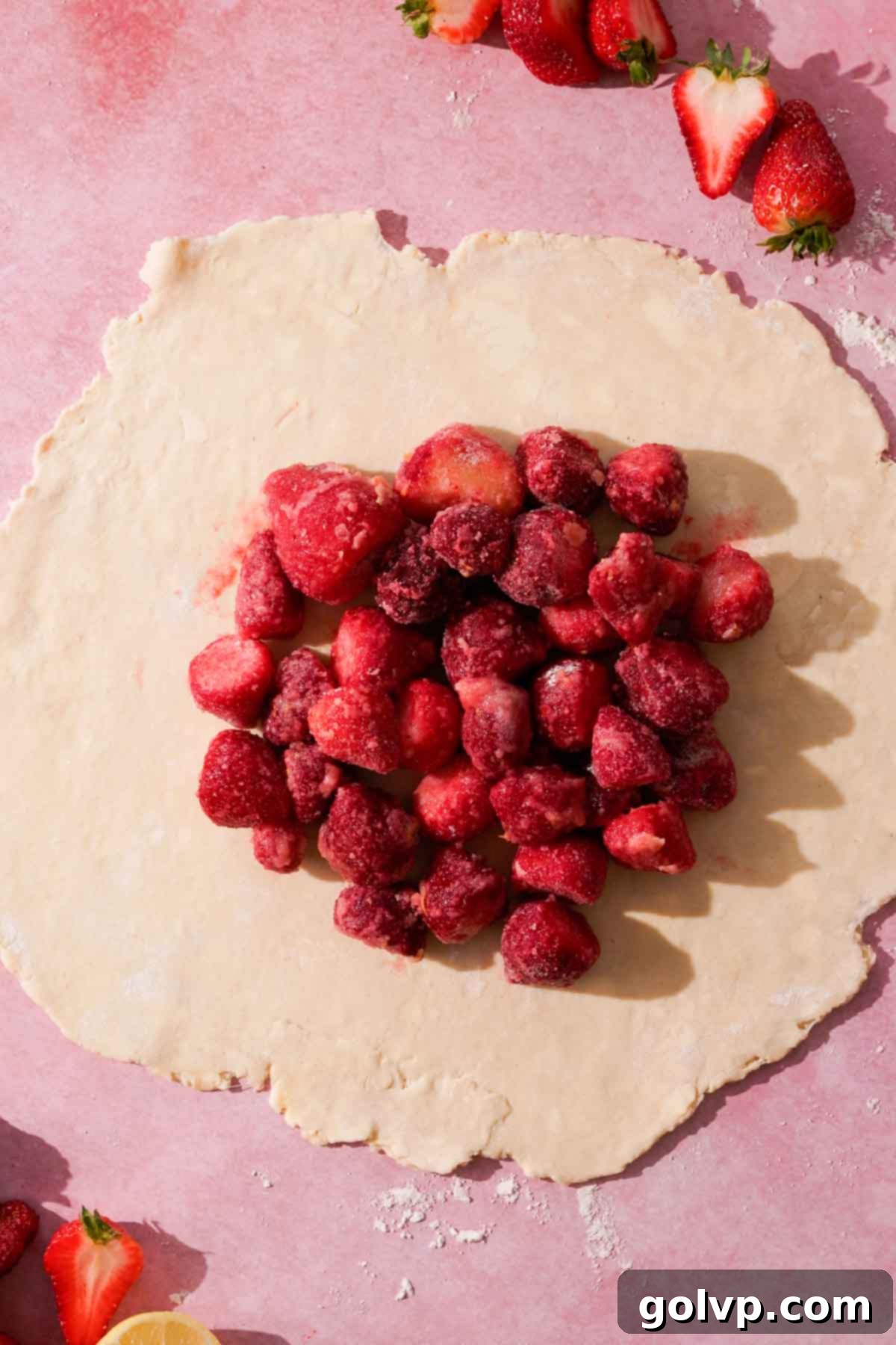 A round disc of dough with a mound of strawberry filling neatly placed in the center, leaving a wide border.