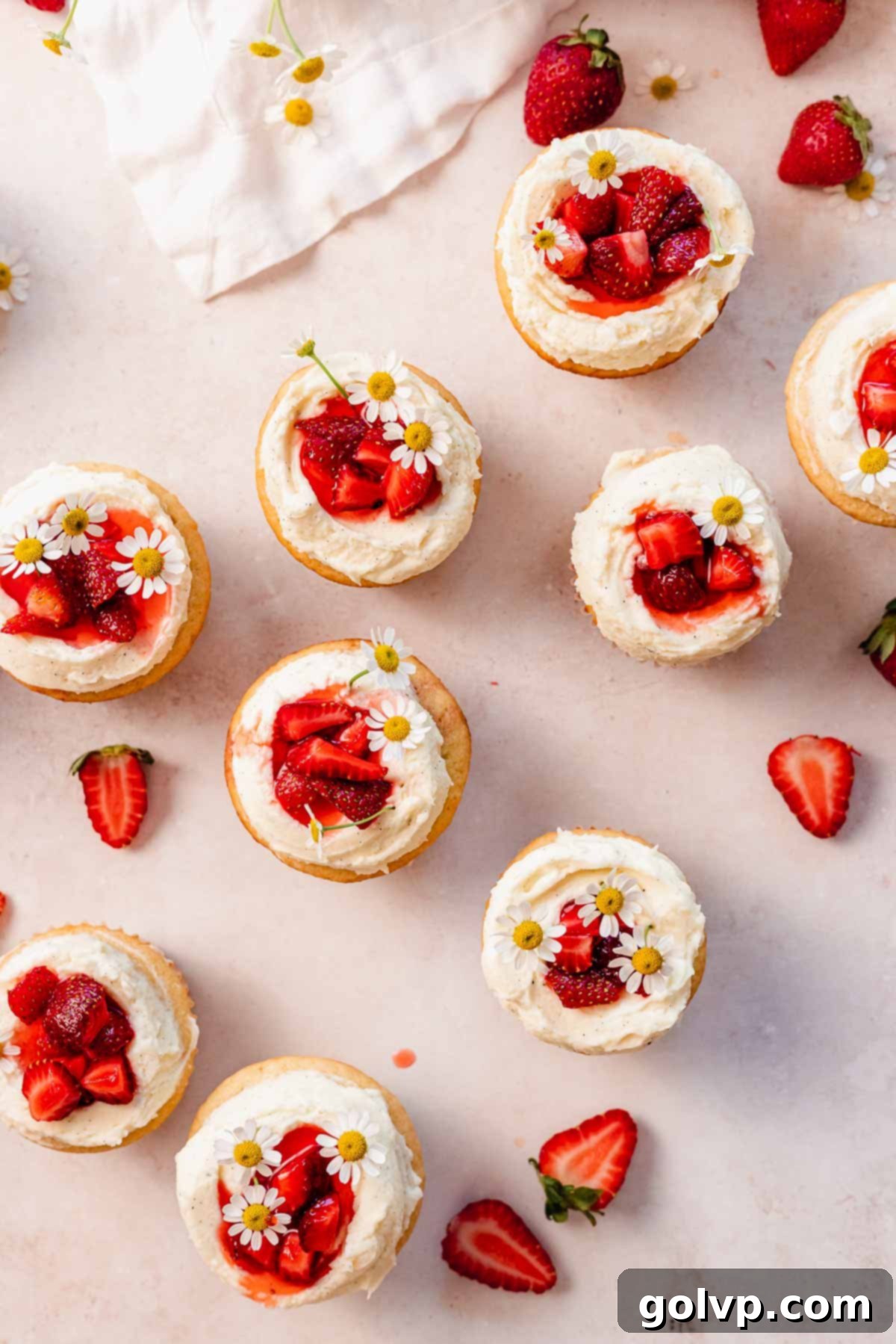 top view of the strawberry white chocolate cupcakes with strawberries and flowers on top