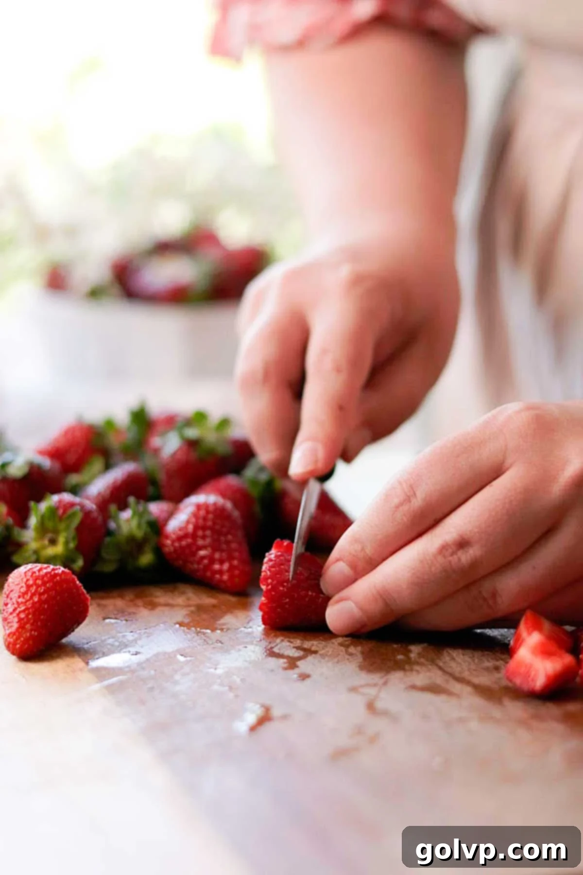 cutting the strawberries into little pieces with a knife