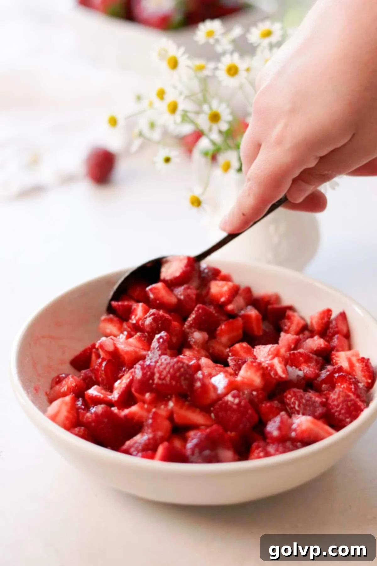 scooping the fresh strawberry sugar lemon mix with a spoon