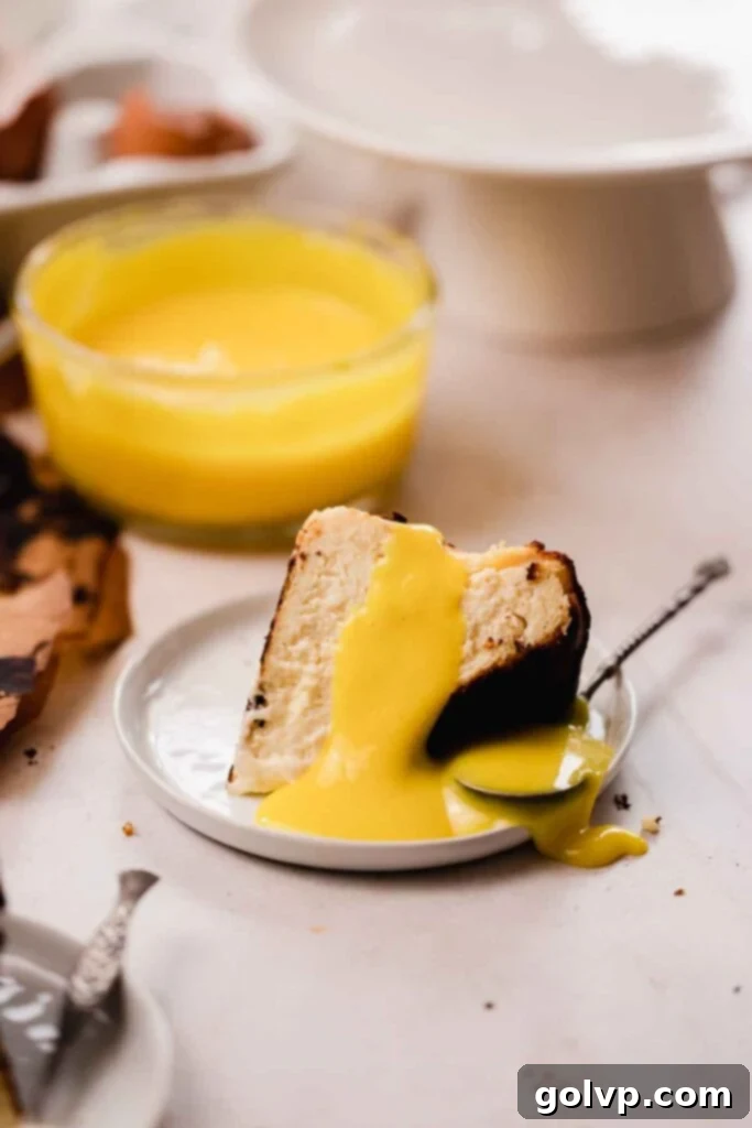 slice of basque cheesecake on plate with warm lemon curd poured on top