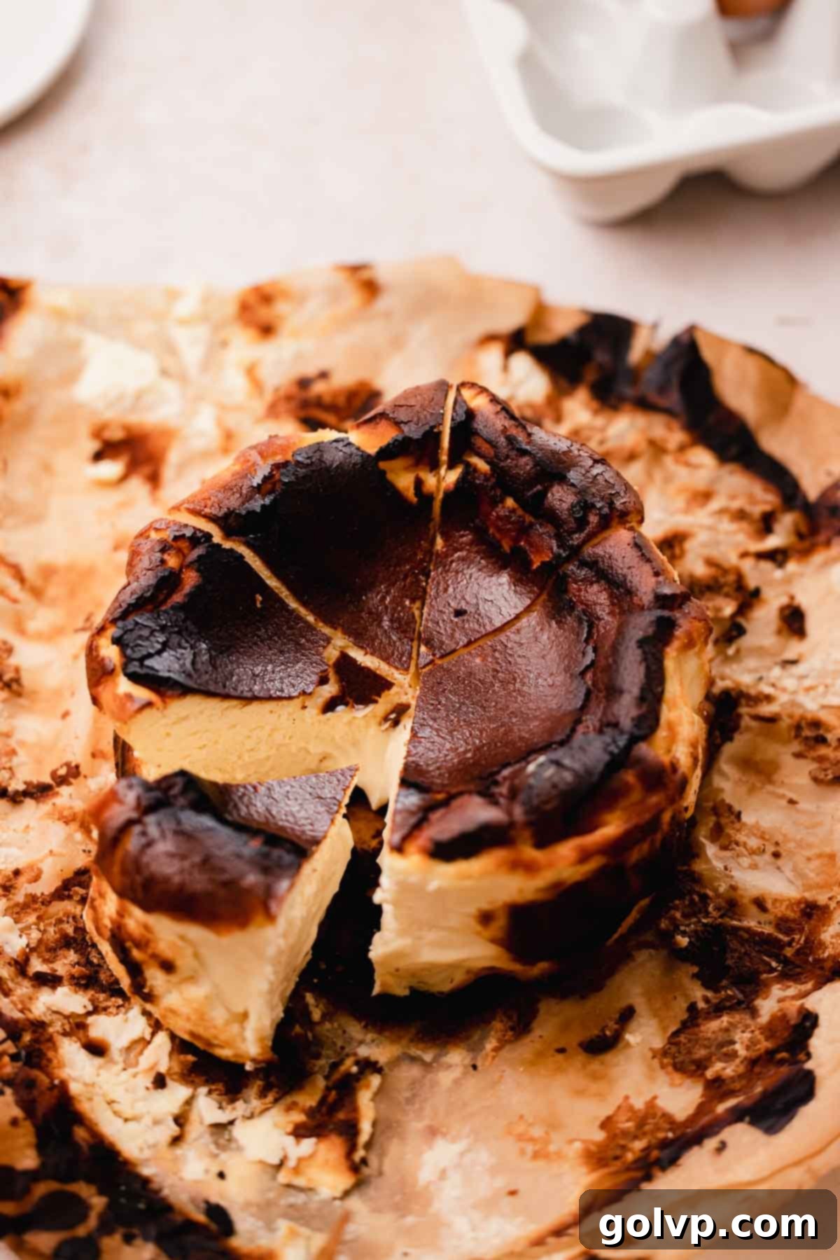 sliced basque burnt cheesecake with creamy center on parchment paper