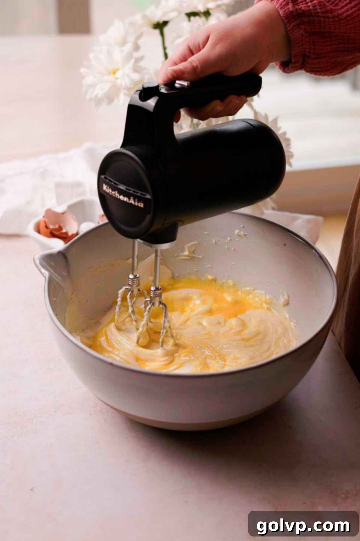mixing eggs into cheesecake batter