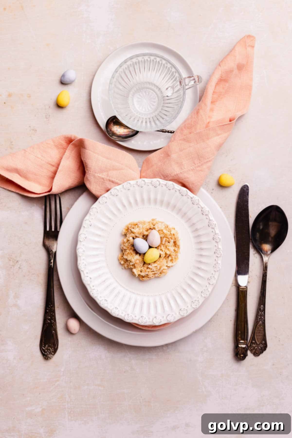 Easter table setting featuring a birds nest cookie and a creative bunny ear napkin fold