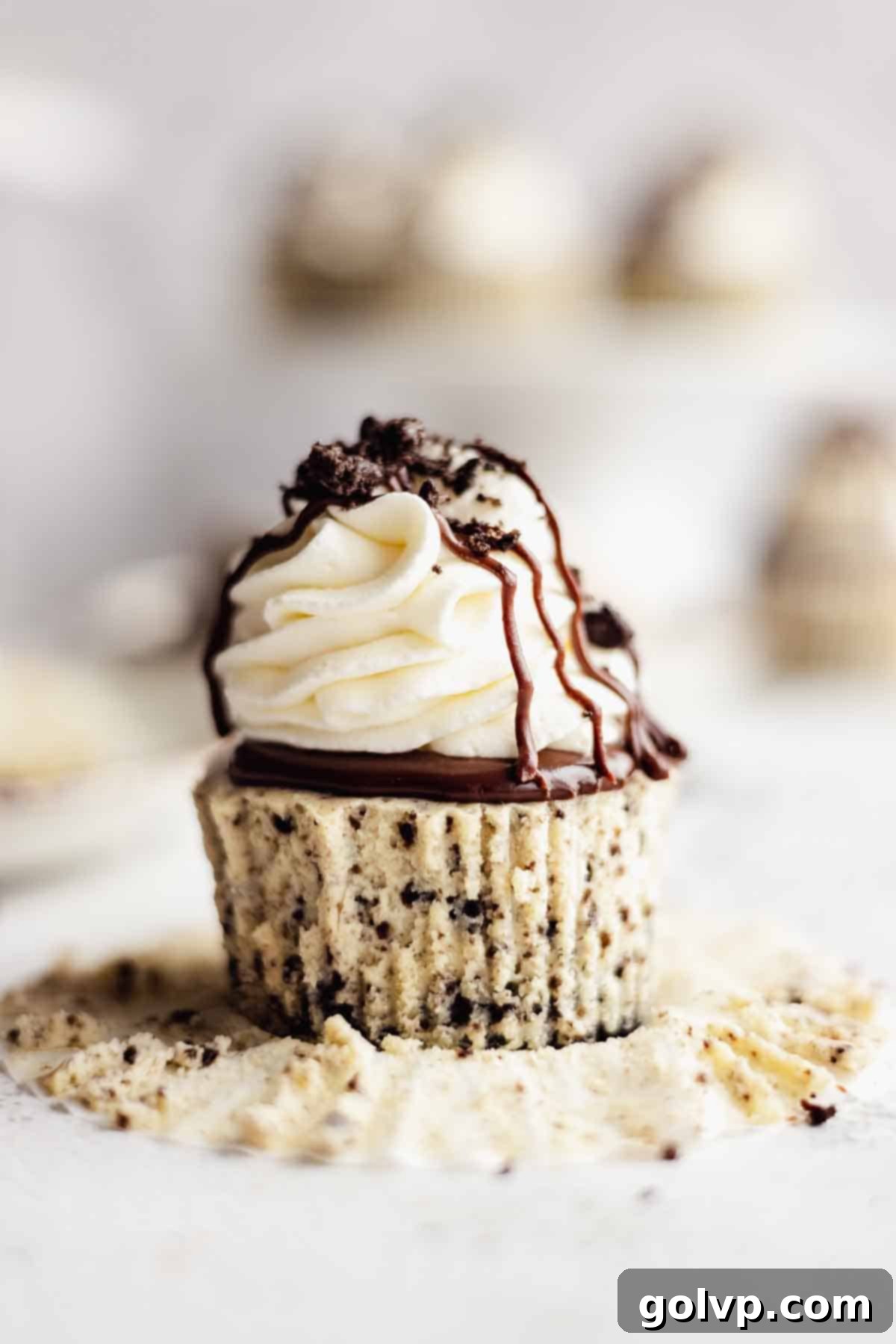 Peeling parchment liner off a perfectly baked mini cheesecake.