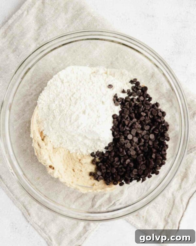 adding heat treated flour, chocolate chips into the fluffy whipped butter