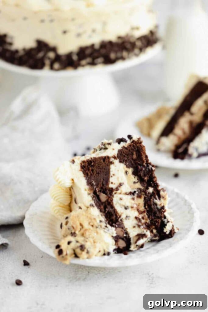 slice of cookie dough cake on a plate, showcasing fudgy brownie and thick edible cookie dough layer